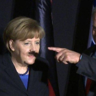 La sombra del dedo y la mano de Netanyahu, sobre el rostro de Merkel.