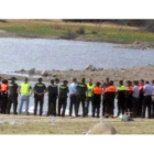 Miembros del equipo de rescate con los dos cuerpos en la orilla.