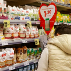 Una mujer escoje artículos marcados con su precio en un supermercado.