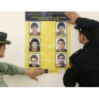 Un guardia civil y un policía cuelgan, el año pasado, un cartel con los etarras más buscados.