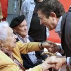 El líder de los socialistas vascos, Patxi López, saluda a dos veteranos militantes