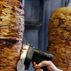 Un hombre corta carne de kebab en un establecimiento de Fráncfort.