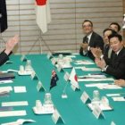 El primer ministro japonés con el casco del equipo de rescate australiano frente a su homóloga.