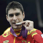 El español Nicolás García muerde su medalla de plata.
