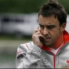 Fernando Alonso habla por el móvil durante uno de los entrenamientos