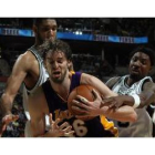 Gasol disputa el balón con dos contrarios.