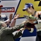 Valentino Rossi aplaude a Pedrosa cuando el piloto de Repson-Honda recibe el trofeo de ganador