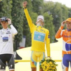 Alberto Contador levanta el puño al cielo parisino para celebrar su victoria, escoltado por Andy Sch