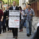 Un licenciado universitario en paro lleva una pancarta en la que pide trabajo, en Londres.