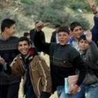 Un grupo de niños palestinos celebra el acuerdo de paz de camino al colegio en Gaza