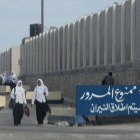 Unas escolares egipcias pasan junto a un cartel que reza "No pasar, abriremos fuego", en el Sinaí.