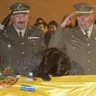 La viuda del soldado llora sobre el féretro durante el acto.