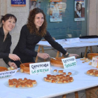 Dos camareras preparan las tapas para servirlas al público.