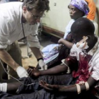 Un médico atiende en el hospital a un hombre herido por una de las explosiones en Kampala.