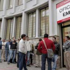 Varias personas hacen cola ante una oficina del Servicio Público de Empleo de Madrid.