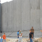 Niños palestinos de camino a la escuela, junto al muro construido por Israel cerca de Qalqilya (Cisjordania).