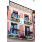 La fachada, además de flores, exhibe un estandarte con capilotes de Riaño y pequeñas vidrieras.