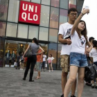 Una pareja de jóvenes se hacen un seli frente a la cadena de ropa Uniqlo, en Pekín.