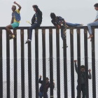 Miembros de la caravana de migrantes que cruzó México a pie hasta la frontera con Estados Unidos trepan el muro fronterizo que separa ambos países el pasado 29 de abril del 2018.