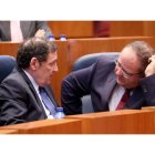 El consejero de Sanidad, Antonio Sáez, conversa con el procurador popular Alejandro Vázquez durante el Pleno de las Cortes. LETICIA PÉREZ