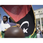 Un hombre sujeta una bandera rebelde en las calles de Trípoli, hoy.