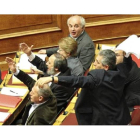 El líder de los comunistas griegos, Girogos Mavrikos, lanza el borrador del acuerdo en plena sesion del Parlamento.