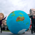 Activistas alemanes con máscaras de Ángela Merkel y el ministro Olaf Schol. ALEXANDER BECHER