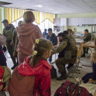 Imagen de un grupo de refugiados a su llegada a la localidad ucraniana de Chuhuiv. FIRMA SERGEY KOZLOV