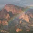 El arco iris en Las Médulas, visible desde el mirador de Orellán, con los picachos de arcilla rodeados de castaños y al fondo a la izquierda la sombra de la cantera de Peña El Rego, ya sin actividad.