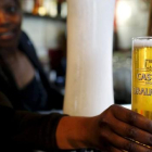 Un camarero sirve una cerveza producida por SABMiller, en Ciudad del Cabo.
