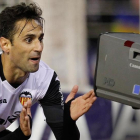 El jugador del Valencia Jonás celebra un gol en Mestalla  ante una cámara de televisión.