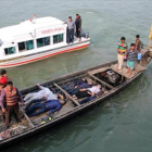 Los equipos de emergencia, rescatan a pasajeros del ferri, tras la colisión, este domingo, en el río Padma, en Bangladesh.