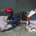 Un sintecho pernocta en el paseo de Sant Joan de Barcelona.
