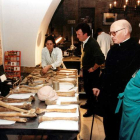 Imagen del abad Viñayo con tres de los investigadores del proyecto científico y ante parte de los restos óseos hallados. NORBERTO