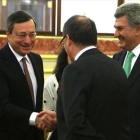 El presidente del BCE, Mario Draghi, saluda al gobernador del Banco de España, Luis María Linde.