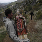 Un joven porta la imagen del santo desde su ermita hasta la campa de la fiesta.