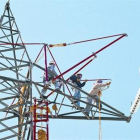 Un grupo de trabajadores de mantenimiento en una torre de alta tensión.