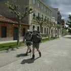 Unos peregrinos caminan por el paseo de la muralla tras llegar a Astorga haciendo la Ruta Jacobea