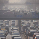 Aspecto del pesado tráfico a mitad de mañana, en medio de un aire contaminado en Pekín (China).