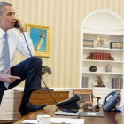 Obama habla con el presidente de la Cámara de Representantes, el republicano John Boehner, en presencia del vicepresidente, Joe Biden, el sábado en el Despacho Oval.