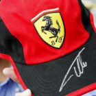 Un fan japonés con la gorra de Ferrari y la firma de Alonso.