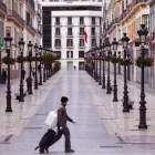 Sólo algunos viandantes cruzan por las calles de una Málaga vacía.