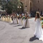 Las reinas y sus damas de honor caminan hacia la iglesia de Santa María para ofrecer sus ramos