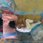 Pacientes que sufren de dengue descansan en un gimnasio cubiertos con mosquiteros en la ciudad de Maasin, Filipinas.