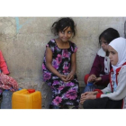 Niñas yemenís esperan para coger agua en una fuente potable en Saná.