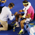 Rafael Nadal es atendido por un médico durante el partido contra Tim Smyczek, durante la segunda ronda del Abierto de Australia.