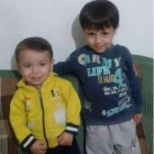 El niño sirio Aylan, de 3 años, y su hermano mayor Galip, de 5, ríen mientras juegan con un osito de peluche.