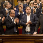 El presidente de la Generalitat, Carles Puigdemont (d), con Junqueras a su lado, recibe el aplauso de los miembros del del Govern.
