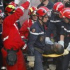 Los bomberos llevan en camilla a Exantus tras ser rescatado de entre los escombros.