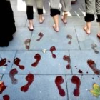 Unas mujeres dejan las huellas de sus pies teñidos durante la manifestación celebrada en Sevilla